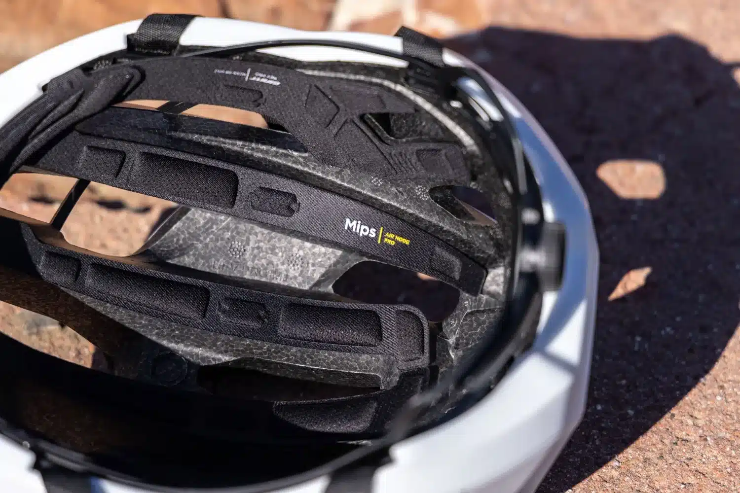 Innenansicht des weißen Giant Rev Pro Rennradhelms, die das schwarze Cinch Pro-Fit-System und das MIPS Air Node Pro-System zeigt.