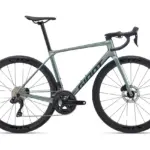 Das Giant TCR Advanced 0 ist ein sportliches Rennrad in heller graugrüner Lackierung mit dem Giant-Logo auf dem Unterrohr. Es verfügt über Carbon-Laufräder, eine Shimano 105 Di2 Gruppe und ein integriertes Cockpit.