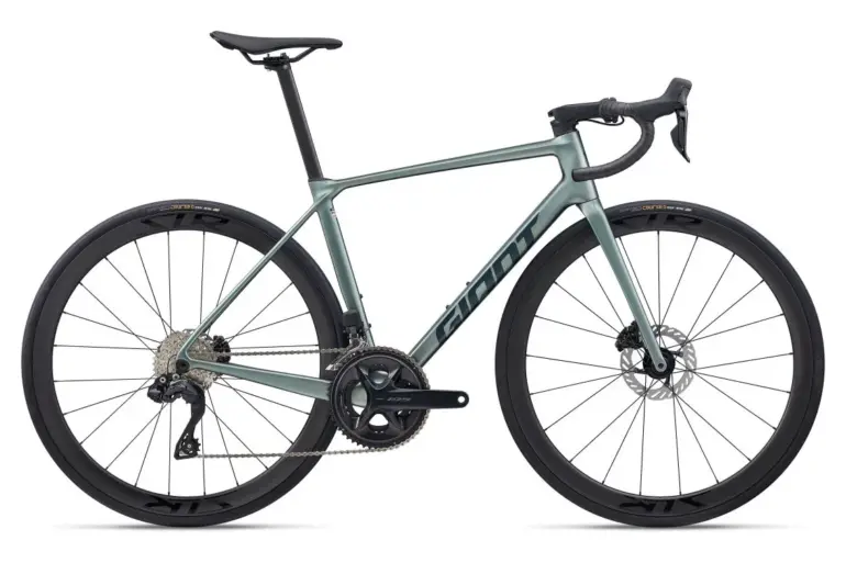 Das Giant TCR Advanced 0 ist ein sportliches Rennrad in heller graugrüner Lackierung mit dem Giant-Logo auf dem Unterrohr. Es verfügt über Carbon-Laufräder, eine Shimano 105 Di2 Gruppe und ein integriertes Cockpit.
