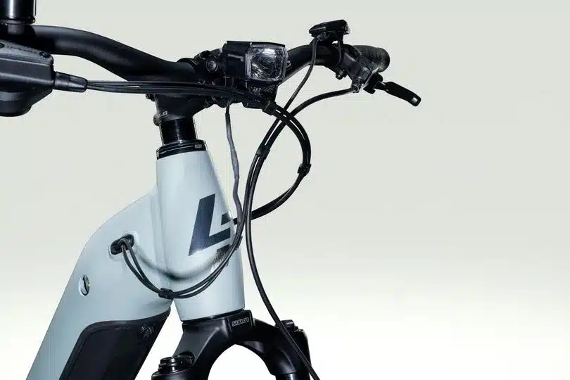 Nahaufnahme des Lenkers und des vorderen Rahmens eines Lapierre E-Explorer E-Trekkingrads mit integrierter Beleuchtung und Bosch LED Remote.