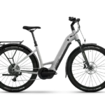 Seitenansicht des Lapierre E-Explorer 8.8 Low 2026 E-Trekkingbikes in Hellgrau mit schwarzem Gepäckträger, Schutzblechen und Reifen.