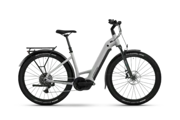 Seitenansicht des Lapierre E-Explorer 8.8 Low 2026 E-Trekkingbikes in Hellgrau mit schwarzem Gepäckträger, Schutzblechen und Reifen.