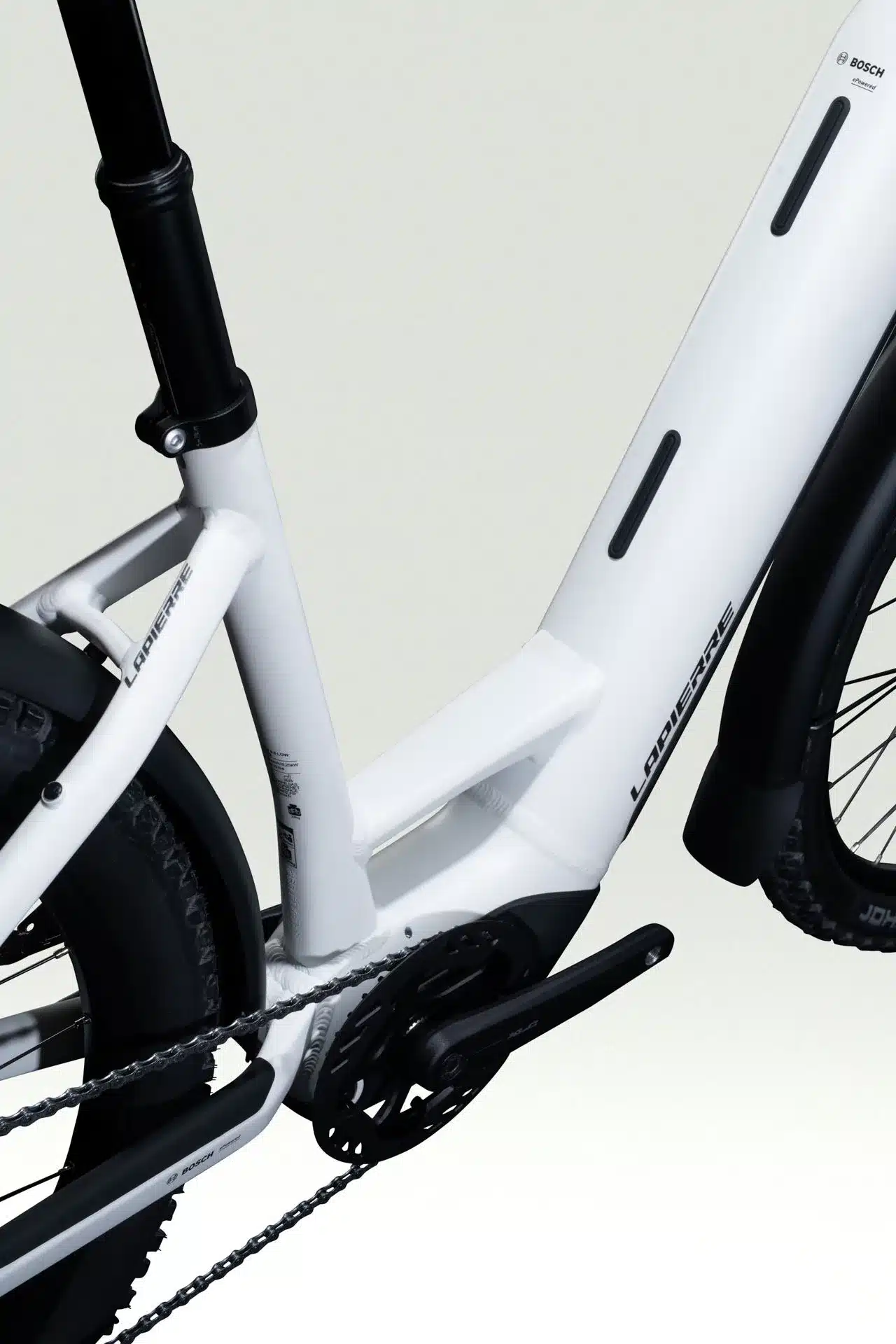 Seitenansicht des weißen Lapierre E-Explorer 8.8 Low E-Trekkingbikes, Fokus auf den Hauptrahmen, Kurbelgarnitur und Teile des Hinterrads.