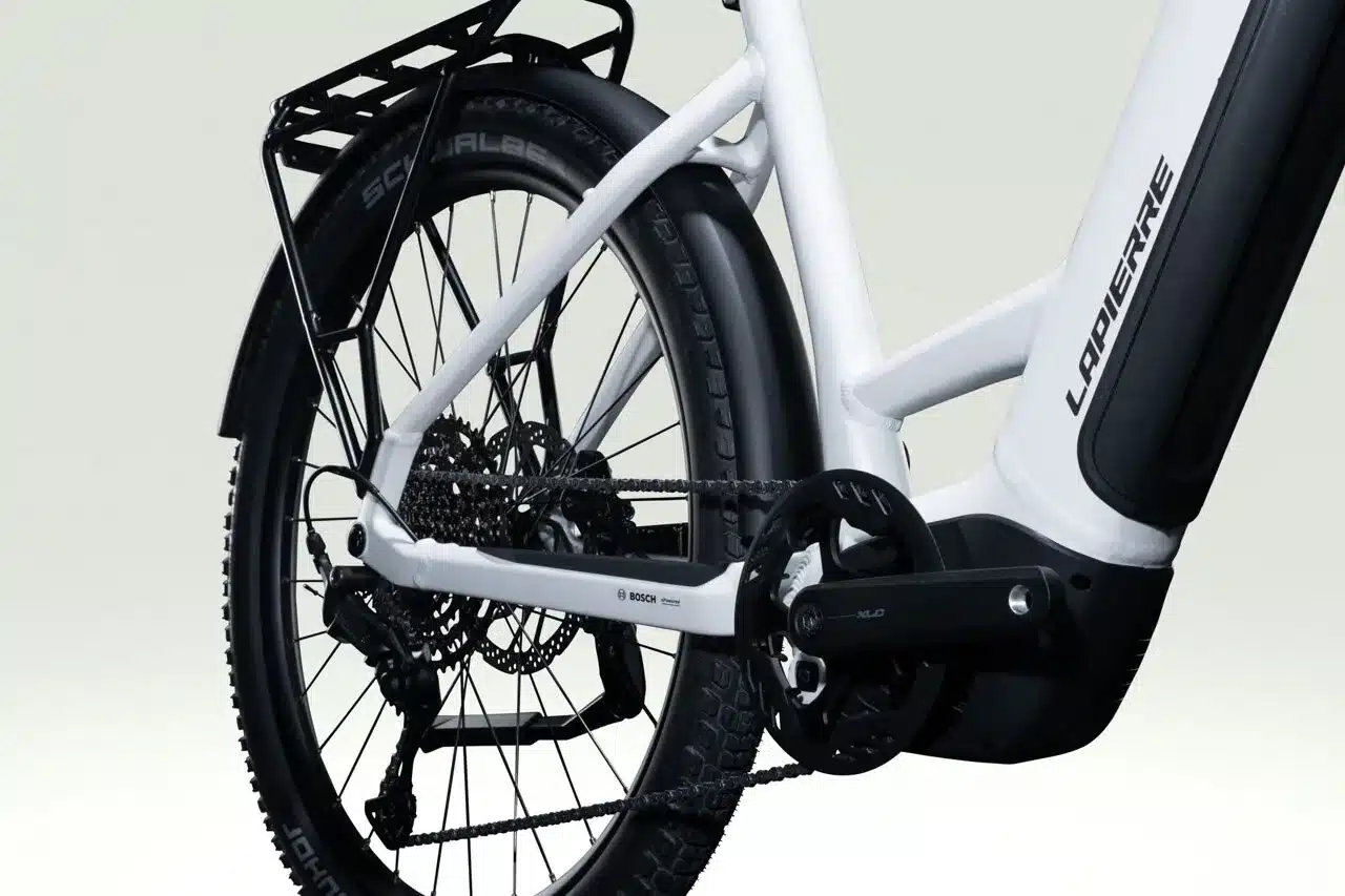 Detailaufnahme des Antriebsstrangs und des Hecks eines weißen Lapierre E-Explorer 8.8 Low E-Trekkingbikes, inklusive Kettenschaltung, Bosch-Motor und Gepäckträger.