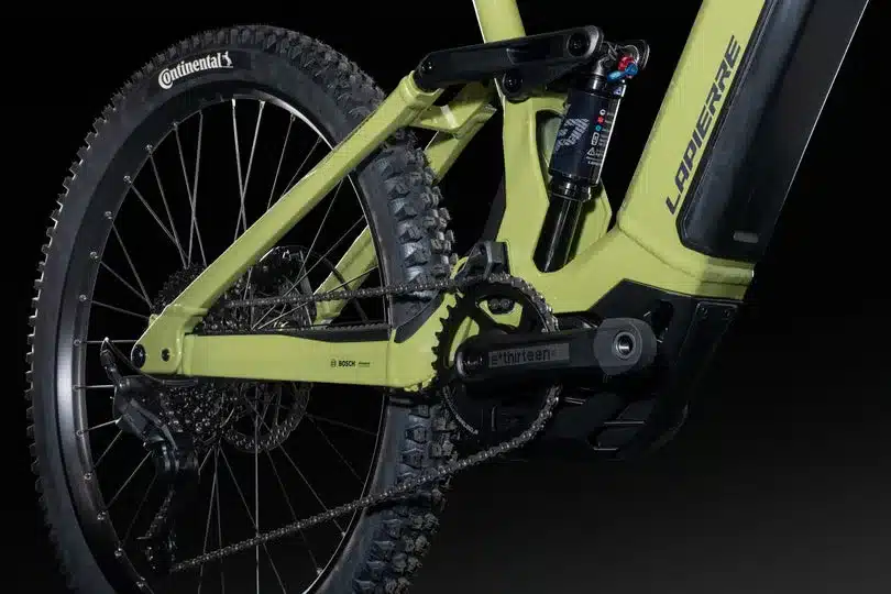 Detailansicht des Hinterbaus eines Lapierre Overvolt E-Mountainbikes mit Fokus auf Federungselement, Kette und Laufrad.