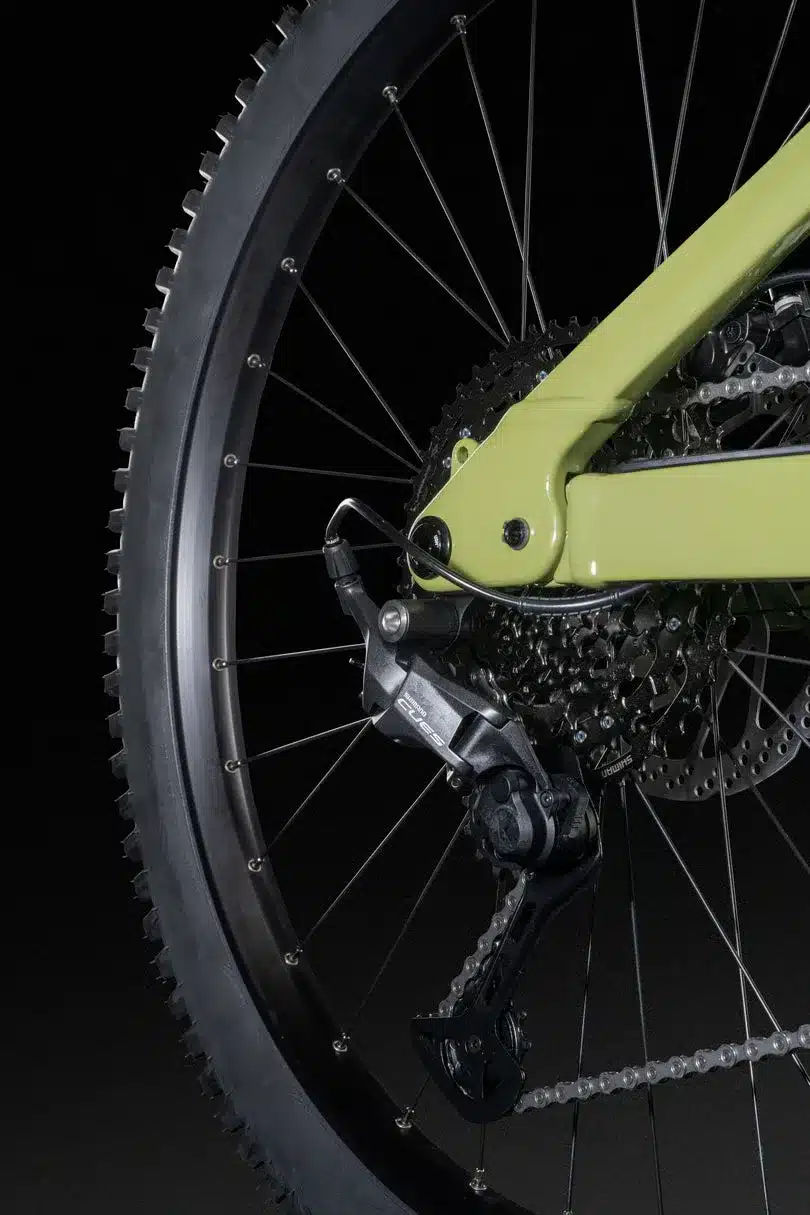 Detailaufnahme des Hinterbaus und des Hinterrads eines E-Mountainbikes, Fokus auf das Schaltwerk und die Kassette mit Kette.