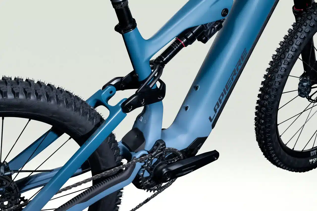Detailansicht des blauen Lapierre Overvolt AM CF 7.8 E-MTBs mit Fokus auf Federungssystem und Hinterrad.