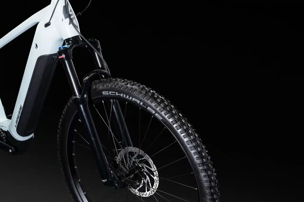 Vorderrad eines weißen Lapierre Overvolt HT 6.6 High E-Mountainbikes mit schwarzer Federgabel und breitem Profilreifen.