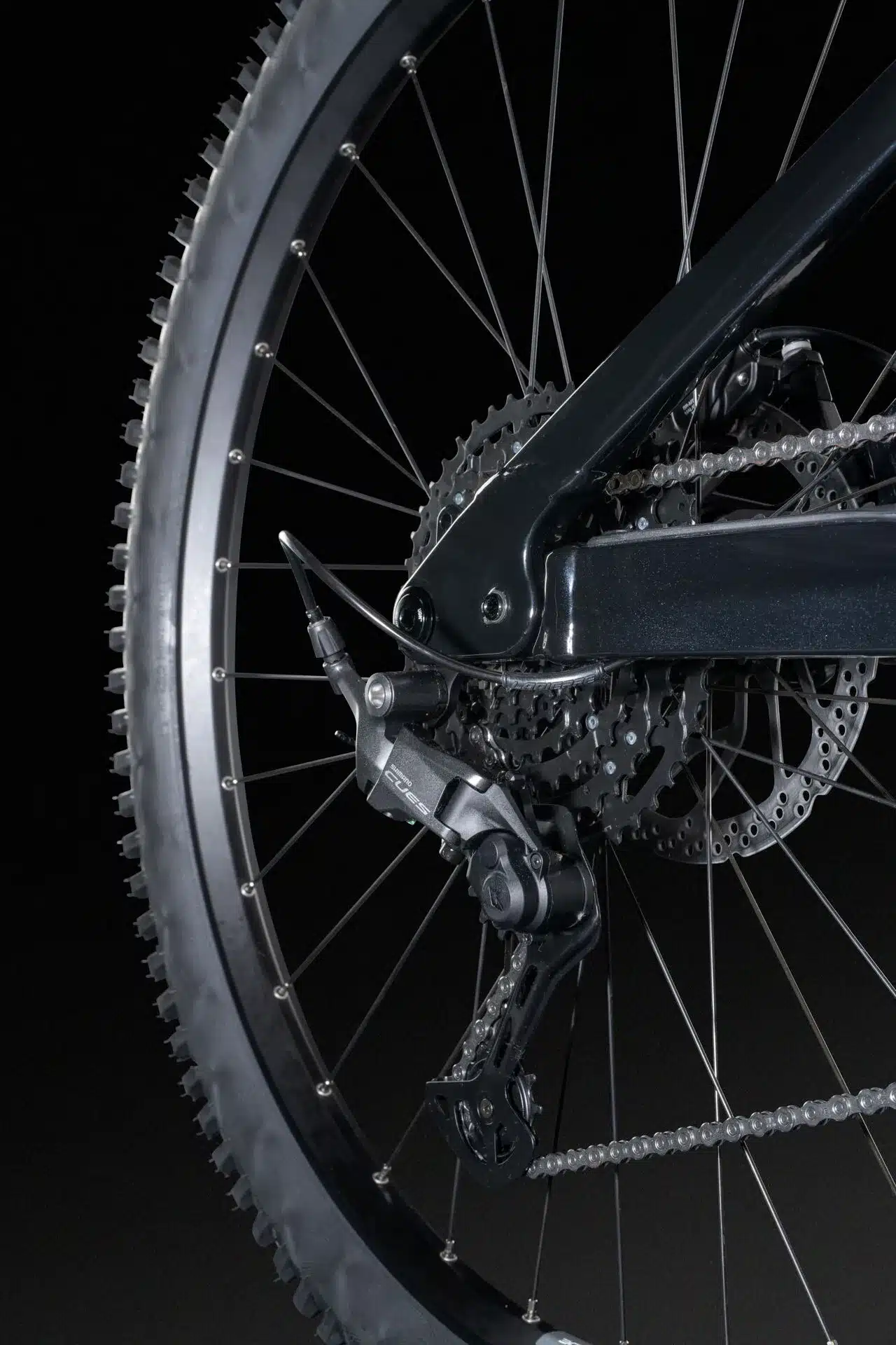 Detailaufnahme des Hinterrads eines E-Mountainbikes, das die Shimano Deore Schaltung, die Kassette und die Bremsscheibe zeigt.