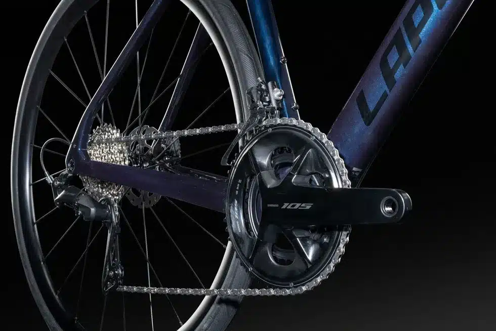 Detailaufnahme des Fahrradrahmens mit Kurbelgarnitur Shimano 105 und des Hinterrads mit Schaltwerk und Kassette.