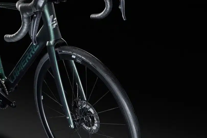 Detailaufnahme eines grünen Lapierre Pulsium 7.0 Rennrads, gezeigt von vorne links, mit Fokus auf das Vorderrad, die Gabel und den Rahmen.