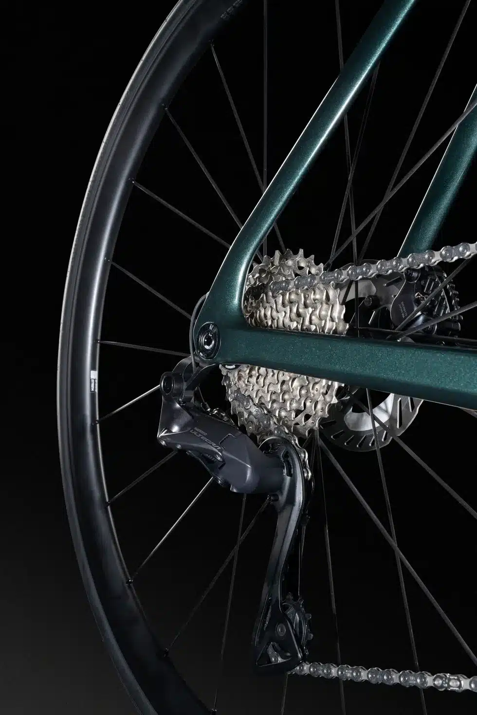 Detailansicht des Hinterrads, der Kassette und des Shimano Ultegra Di2 Schaltwerks eines grünen Lapierre Xelius DRS 7.0 Rennrads auf schwarzem Hintergrund.