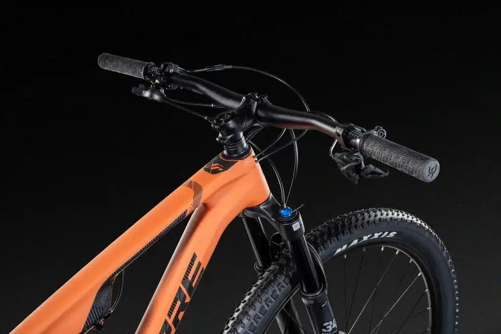Vorderansicht eines orangefarbenen Lapierre XRM 6.9 Mountainbikes mit Fokus auf Lenker, Vorbau, Federgabel und Vorderrad.