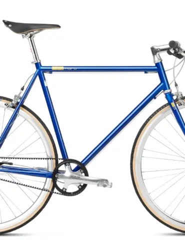 Seitenansicht eines blauen Mikamaro Anniversary Edition Urban Bikes mit hellbraunen Reifen und goldenen Logos.