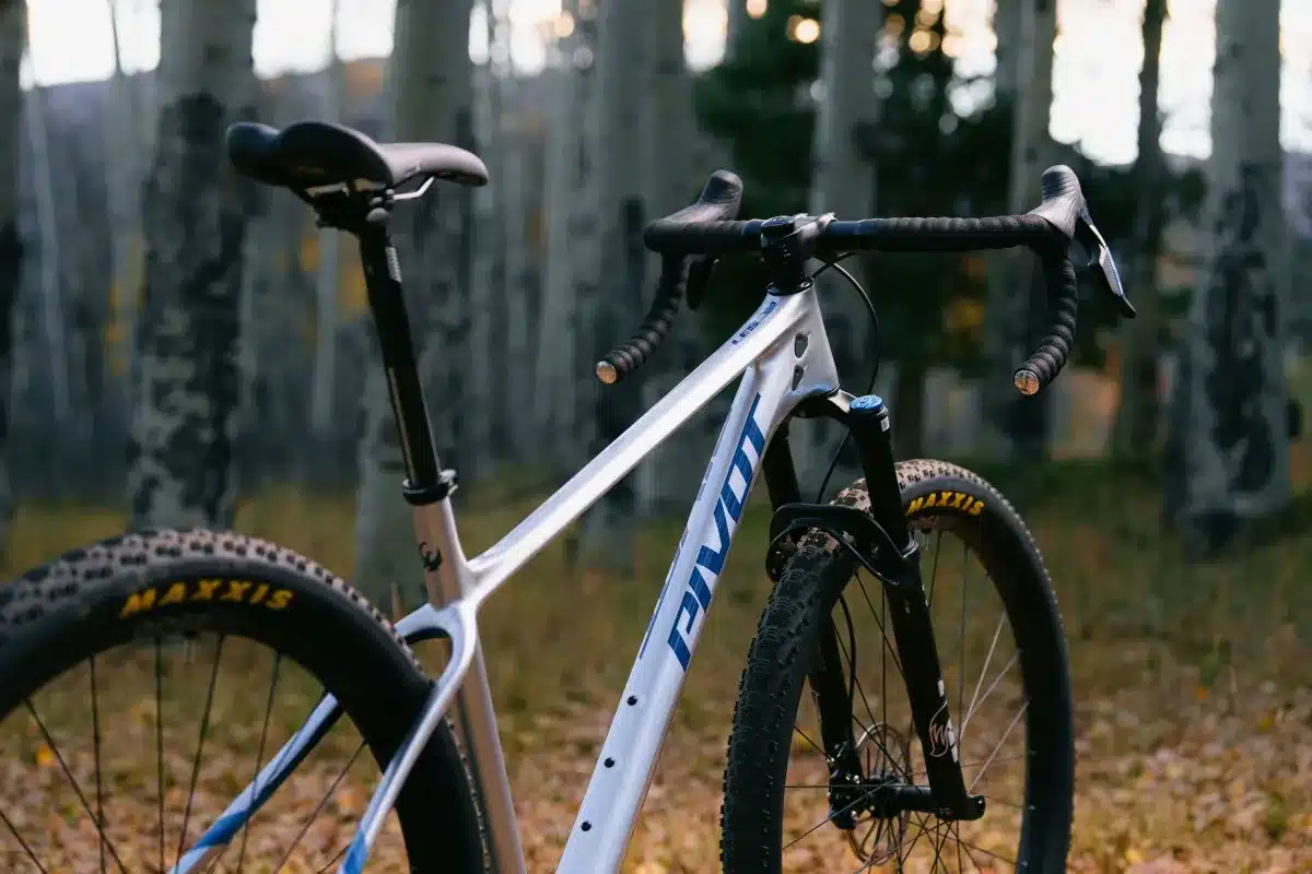 Nahaufnahme des Rahmens und des Cockpits eines silbernen Pivot LES SL Drop Bar Fahrrads, das für den Geländeeinsatz konzipiert ist.