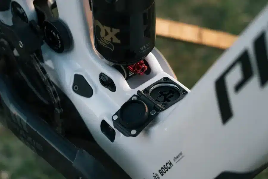 Detailansicht des Rahmens eines Pivot Shuttle LT E-Enduro Bikes mit Fokus auf den Dämpfer und den Ladeanschluss.