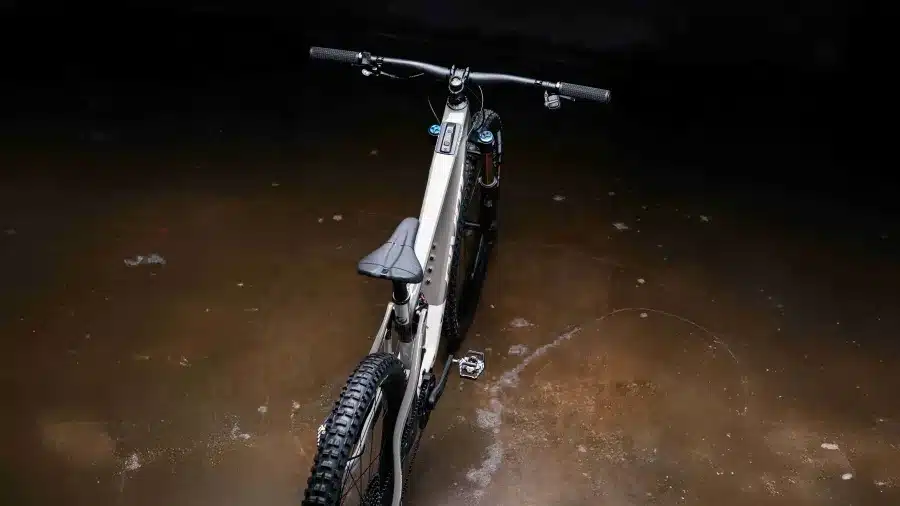 Oberansicht eines hellgrauen Pivot Shuttle SL/AM E-Mountainbikes mit Fokus auf den Carbonrahmen, Lenker und Sattel.