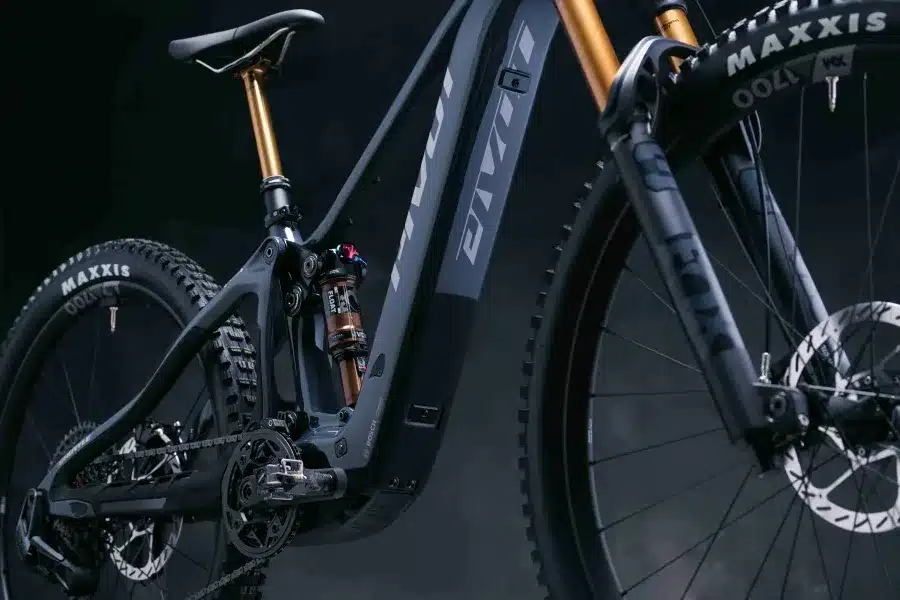Seitenansicht eines dunkelgrauen Pivot Shuttle SL/AM E-Mountainbikes mit Fokus auf den Hinterbau, Dämpfer, Carbonrahmen und Vorderrad mit FOX Gabel.
