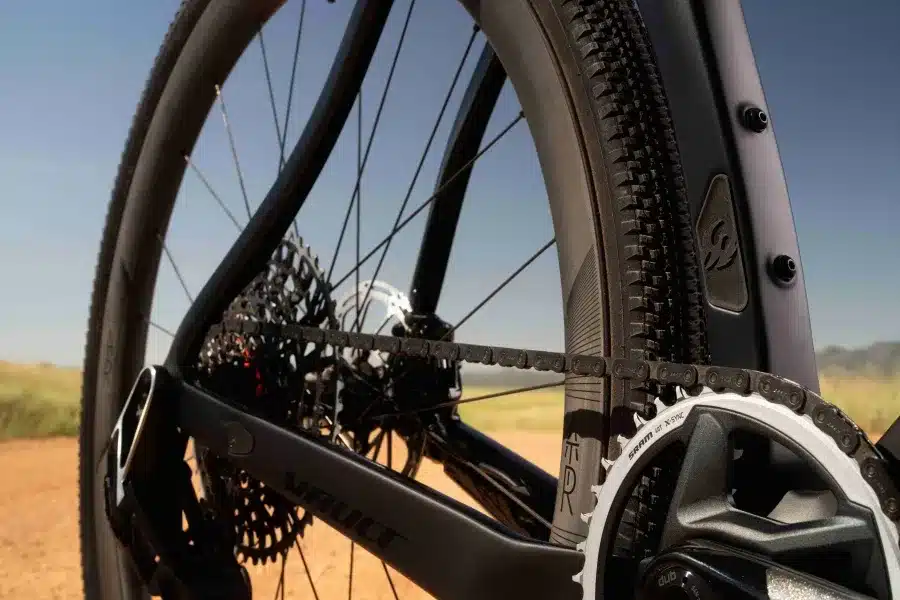 Detailaufnahme des Antriebsstrangs eines schwarzen Pivot Vault Gravelbikes mit Blick auf Kette, Kassette und Kurbelgarnitur. Ein Teil des Hinterrads und des Rahmens sind sichtbar.