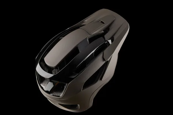 Ein schwarzer Mountainbike-Helm mit vielen Belüftungsöffnungen und einem verstellbaren Visier, aufgenommen vor einem schwarzen Hintergrund.