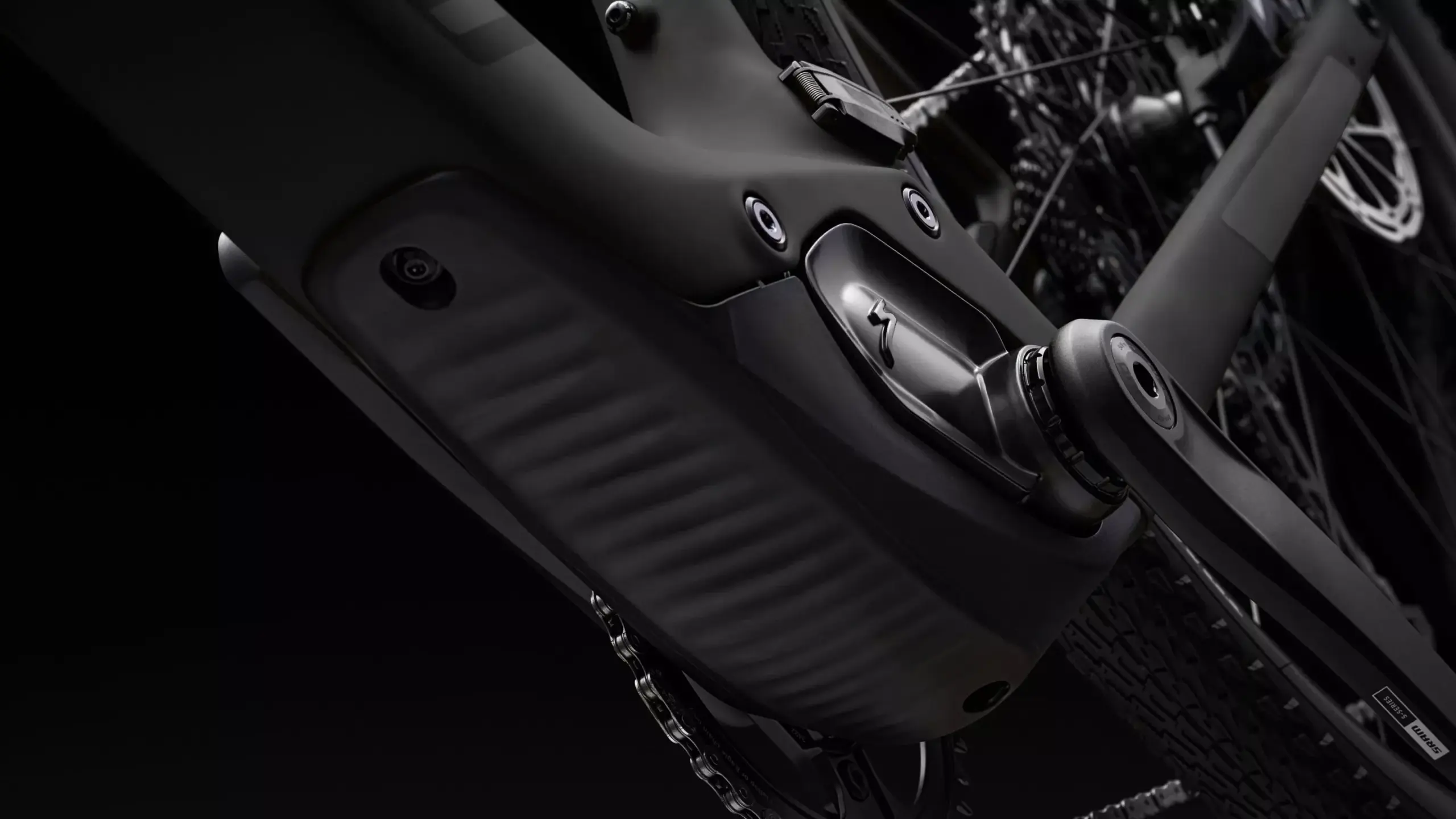 Nahaufnahme des schwarzen Carbonrahmens eines S-Works Turbo Creo 2 E-Gravelbikes mit Fokus auf das integrierte Antriebssystem und die Kurbelgarnitur.