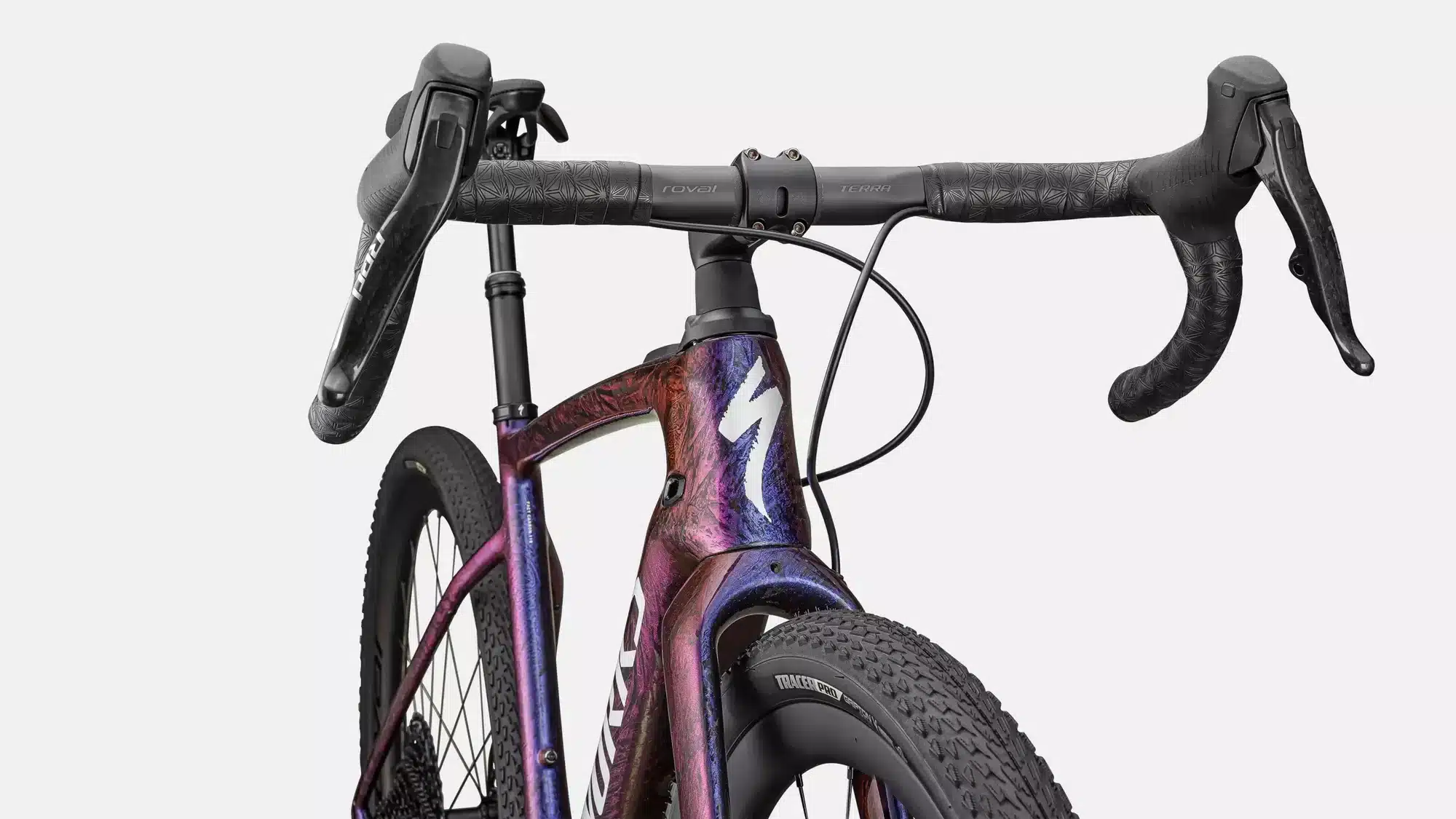 Detailaufnahme des vorderen Teils eines S-Works Turbo Creo 2 Fahrrads, mit Fokus auf den bunten Carbonrahmen, den Lenker mit SRAM RED/XX1 Eagle AXS Schalthebeln und den grobstolligen Vorderreifen.