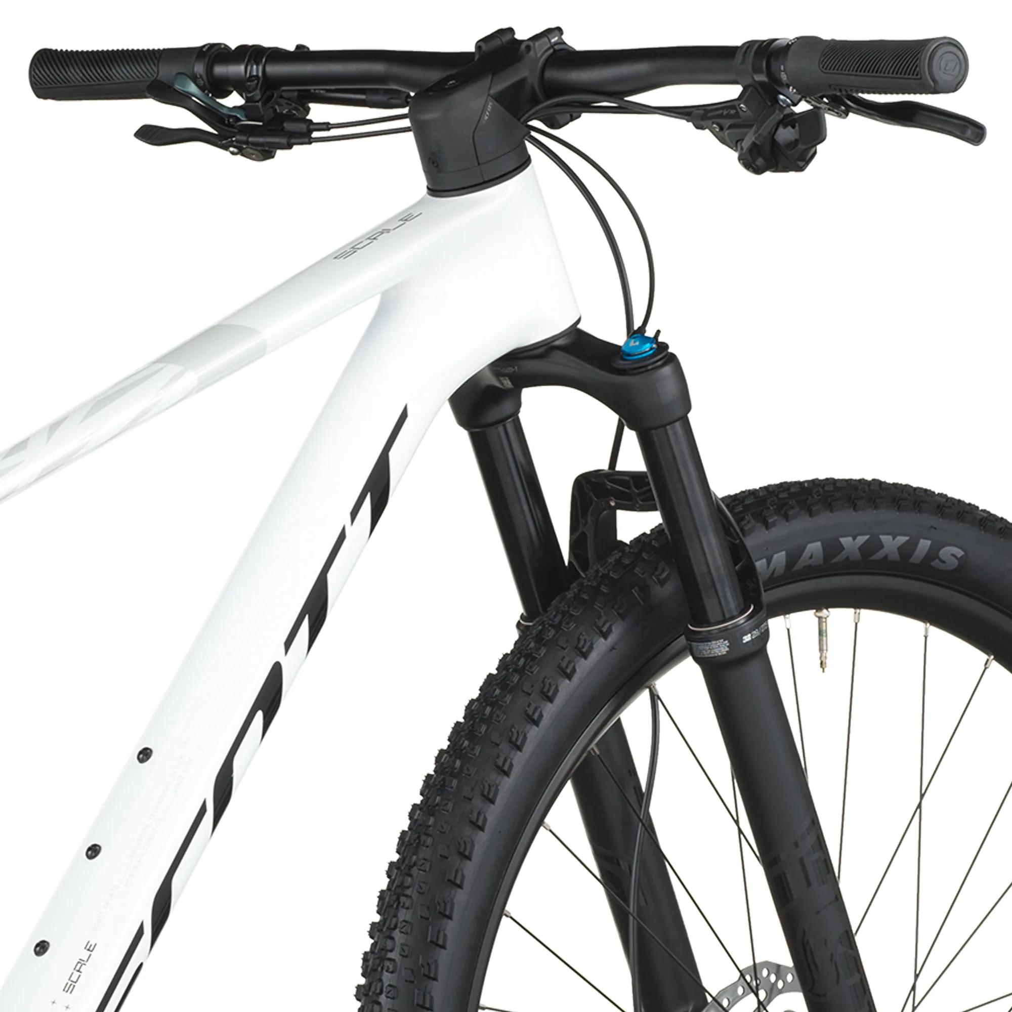 Detailbild des Scott Scale 910 Mountainbikes mit Fokus auf den weißen Rahmen, die schwarze FOX 32 Federgabel, den Lenker und das Vorderrad mit Maxxis Rekon Race Reifen.