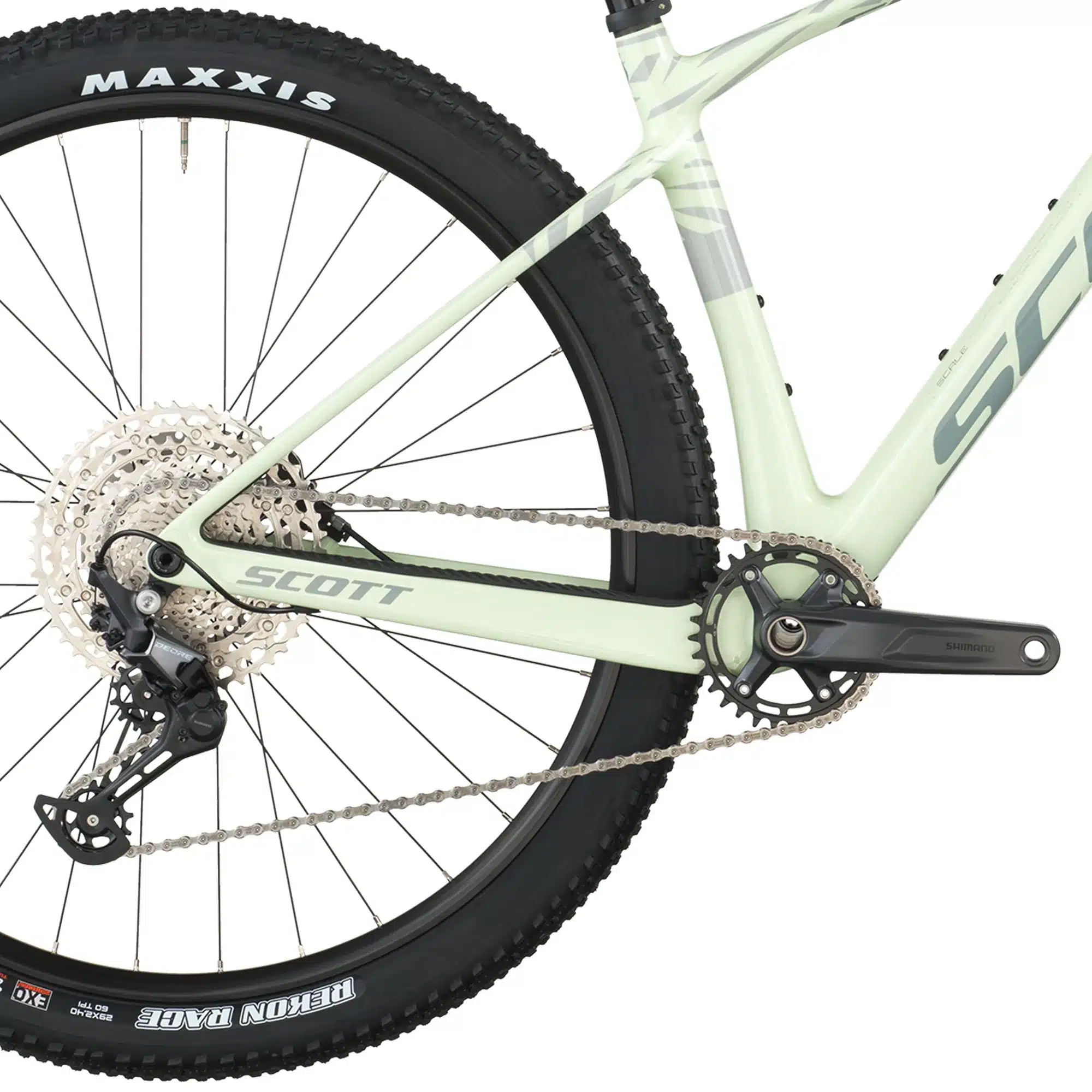Detailansicht des Antriebsstrangs und des Hinterrads eines weißen SCOTT Scale 920 Mountainbikes mit silberner Kassette, schwarzem Schaltwerk und einer Kette, die über das Kettenblatt läuft. Die Reifenmarke MAXXIS ist am Hinterrad sichtbar.