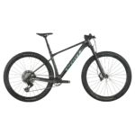 Das SCOTT Scale RC Team ist ein dunkles Carbon-Mountainbike mit dem Scott-Logo auf dem Unterrohr und hellblauen Akzenten. Es hat 29-Zoll-Räder mit Maxxis Rekon Race Reifen, eine RockShox Federgabel und eine SRAM Eagle AXS Schaltung.