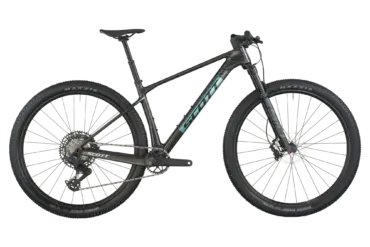 Das SCOTT Scale RC Team ist ein dunkles Carbon-Mountainbike mit dem Scott-Logo auf dem Unterrohr und hellblauen Akzenten. Es hat 29-Zoll-Räder mit Maxxis Rekon Race Reifen, eine RockShox Federgabel und eine SRAM Eagle AXS Schaltung.