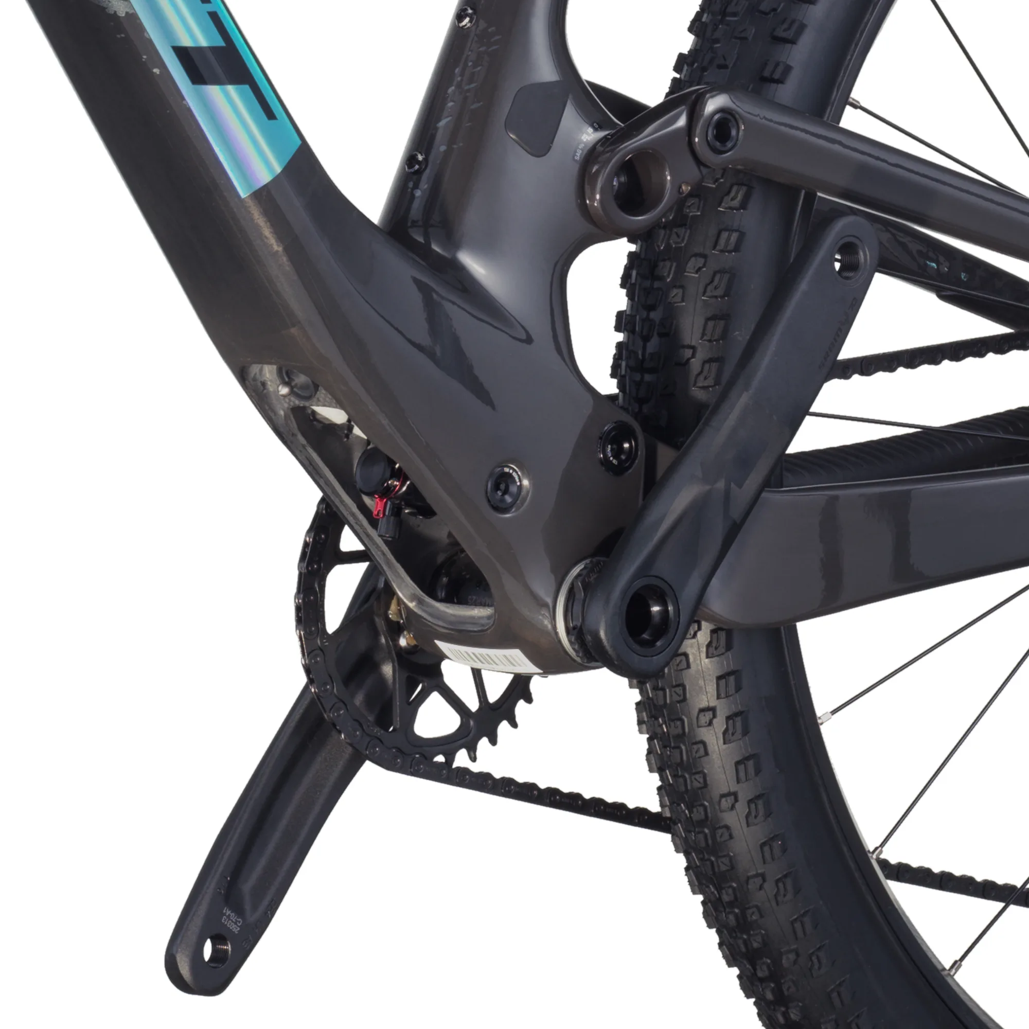 Detailaufnahme des carbonfarbenen Hinterbaus eines Scott Spark RC Team Mountainbikes mit sichtbarer SRAM Kette, Kettenblatt und Hinterrad mit grobstolliger Bereifung.