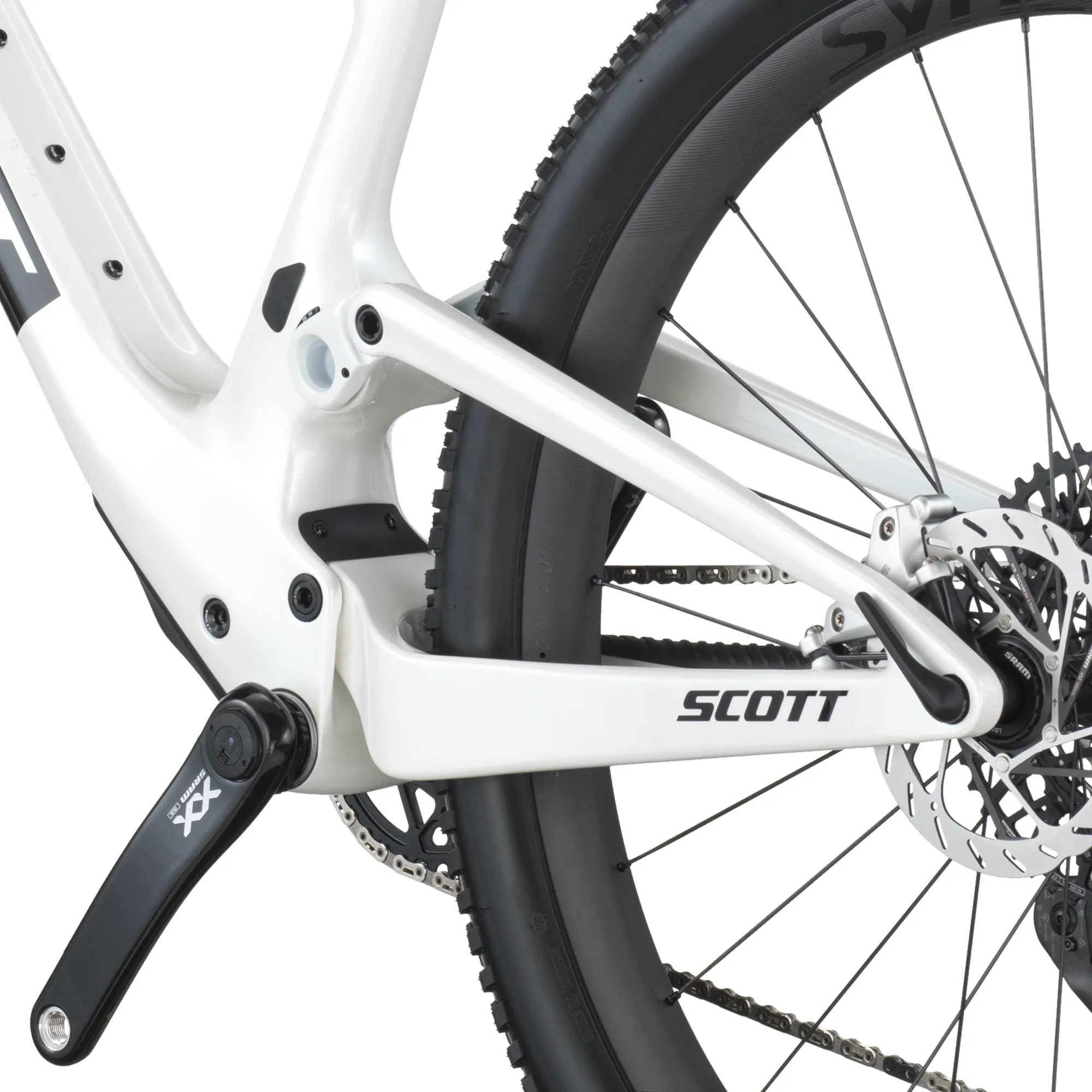 Detailansicht des Hinterbaus eines weißen SCOTT Spark RC World Cup EVO Mountainbikes mit schwarzer SRAM XX SL Eagle AXS Kurbel und einem Teil des Syncros Carbon-Laufrads.