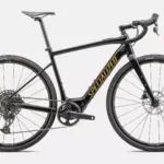 Seitenansicht eines schwarzen Specialized Turbo Creo 2 Comp E5 E-Allroad-Bikes mit gelbem 'SPECIALIZED' Schriftzug auf dem Unterrohr, weißen Felgenbeschriftungen und einer kompletten Schaltgruppe.