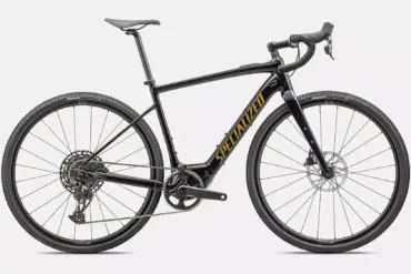 Seitenansicht eines schwarzen Specialized Turbo Creo 2 Comp E5 E-Allroad-Bikes mit gelbem 'SPECIALIZED' Schriftzug auf dem Unterrohr, weißen Felgenbeschriftungen und einer kompletten Schaltgruppe.