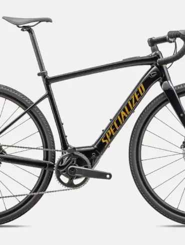 Seitenansicht eines schwarzen Specialized Turbo Creo 2 Comp E5 E-Allroad-Bikes mit gelbem 'SPECIALIZED' Schriftzug auf dem Unterrohr, weißen Felgenbeschriftungen und einer kompletten Schaltgruppe.