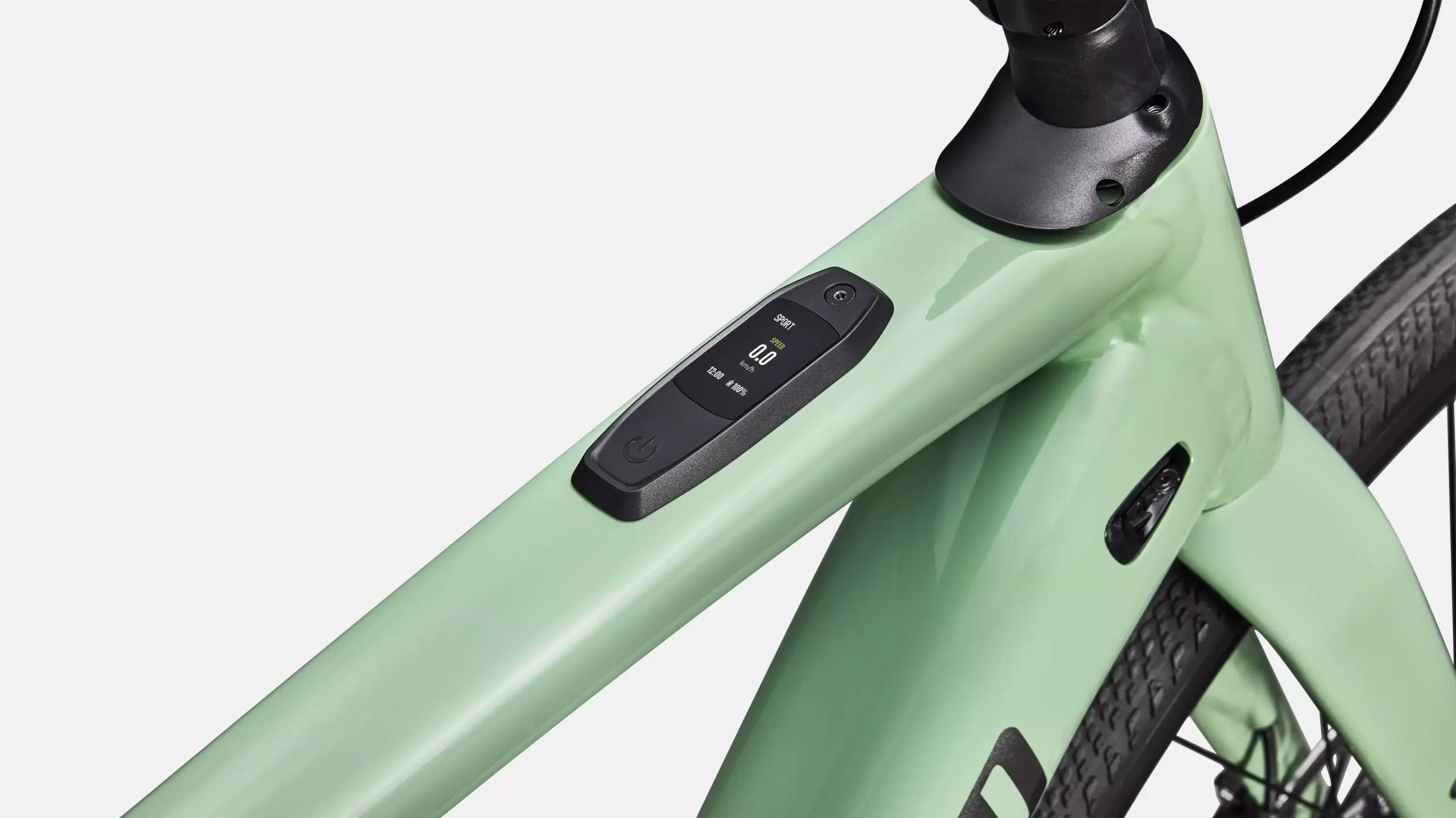 Grünes E-Rennrad mit integriertem Display und Bedienelementen am Steuerrohr.