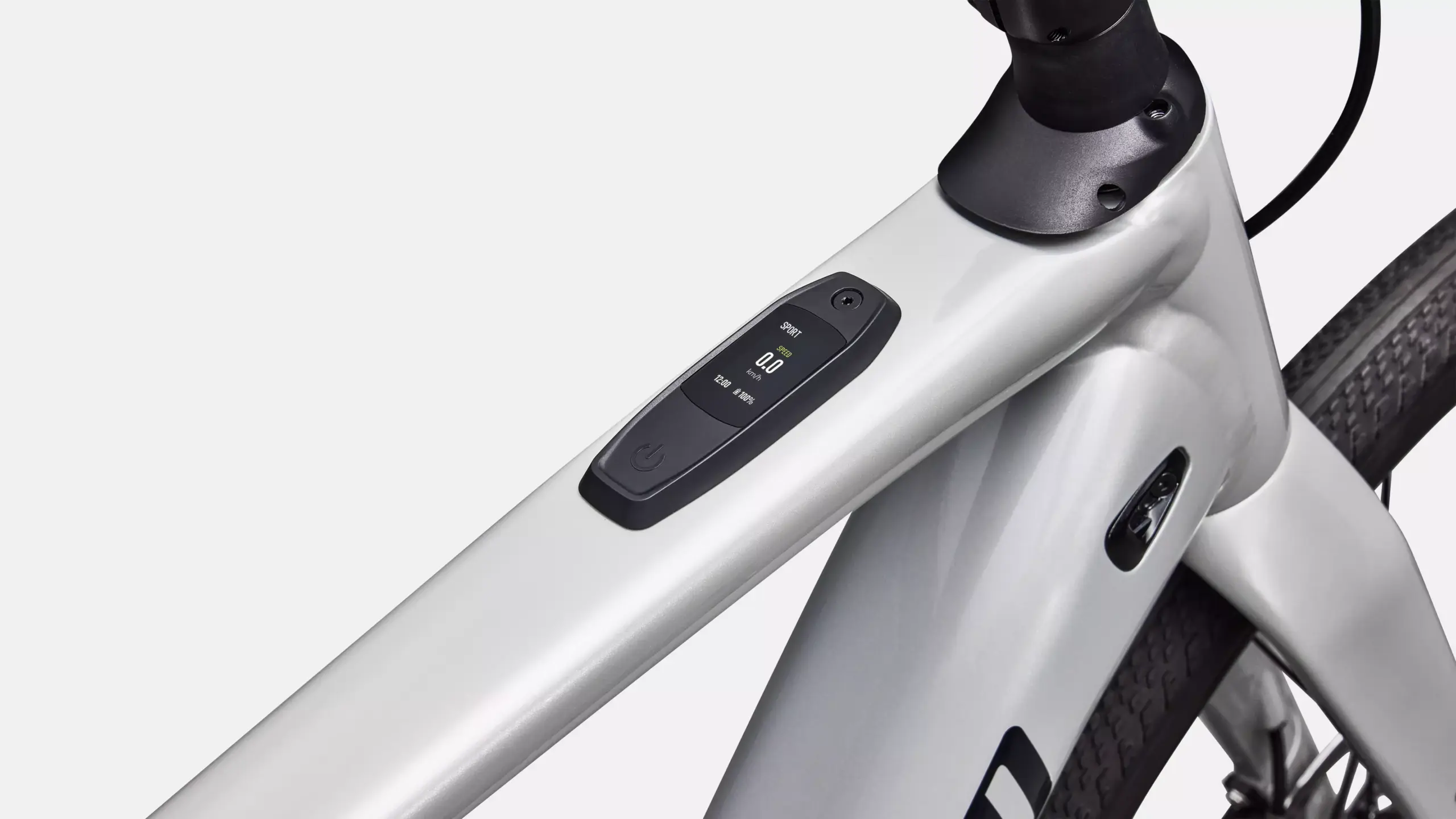 Nahaufnahme des silbernen Rahmens eines Specialized Turbo Creo 2 E-Gravelbikes mit integriertem Display, das Geschwindigkeit und Batteriestatus anzeigt.