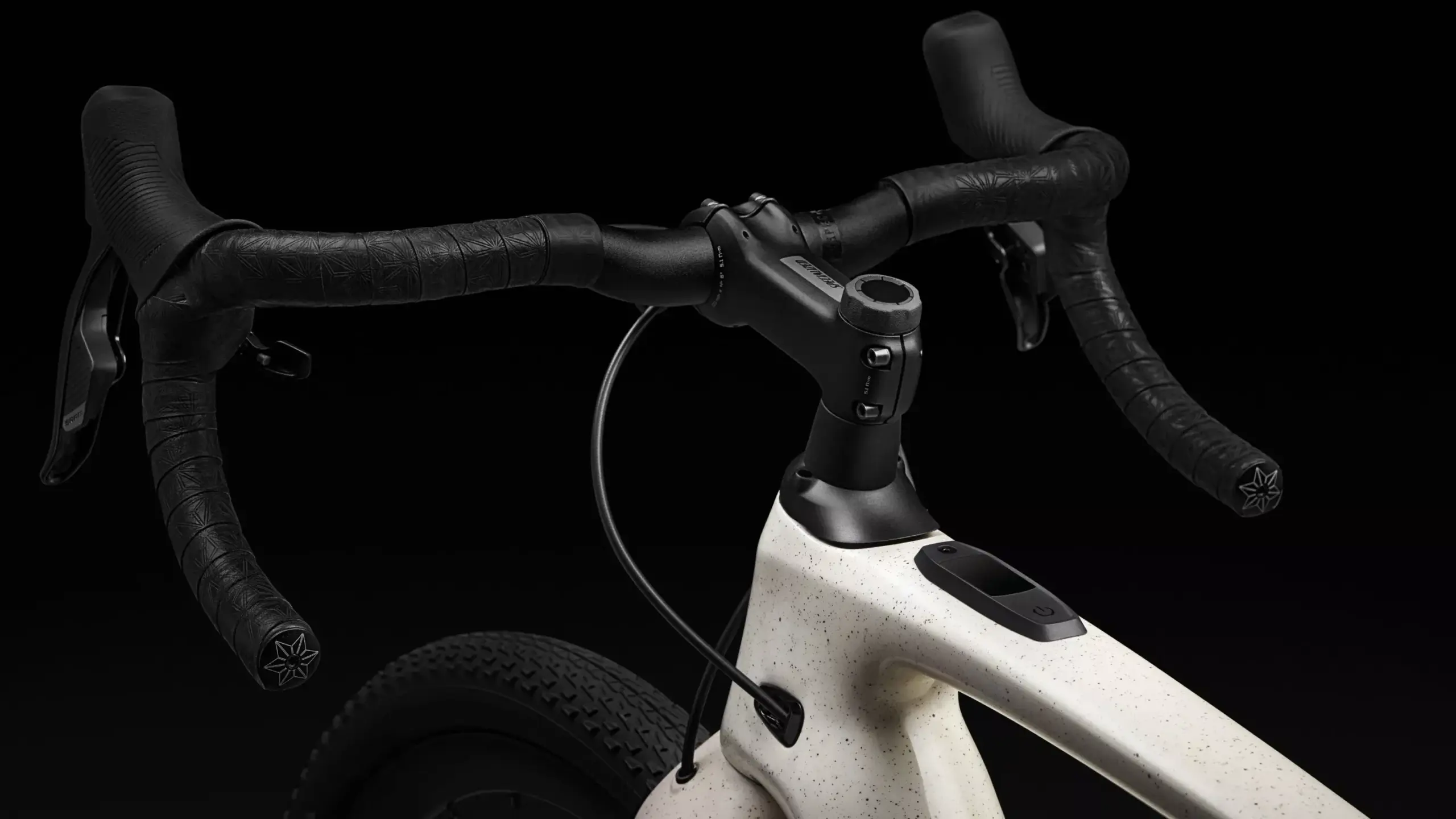 Nahaufnahme des Lenkers, Vorbaus und des vorderen Rahmens eines Specialized Turbo Creo 2 Expert E-Gravelbikes mit einem dezenten Display im Oberrohr.