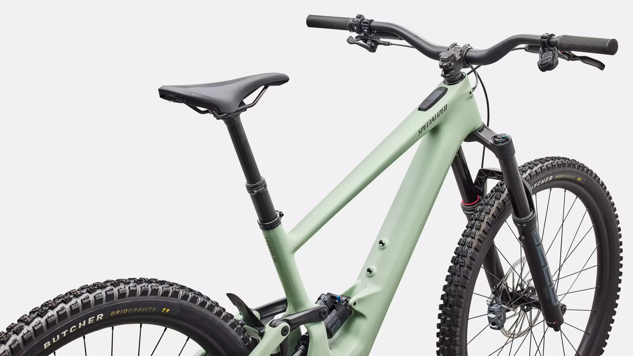 Detailaufnahme eines Specialized Turbo Kenevo SL 2 Comp E-Mountainbikes in mattgrüner Farbe, gezeigt von der Seite mit Fokus auf den Rahmen, die Federgabel, den Lenker und das Vorderrad.