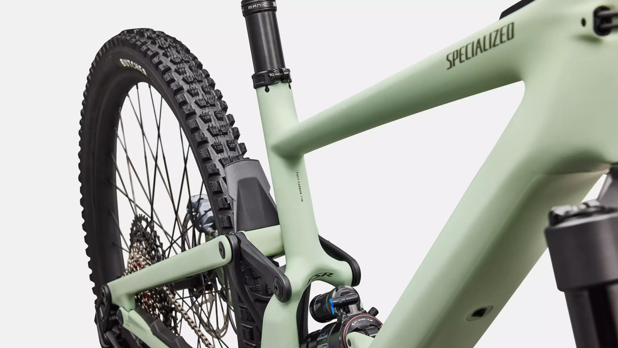 Detailansicht des Hinterbaus und der Federungskomponenten eines Specialized Turbo Kenevo SL 2 Comp E-Mountainbikes, mit Fokus auf den Carbonrahmen, die RockShox Super Deluxe Select Dämpfer und den Butcher GRID GRAVITY Reifen.