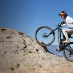 Mountainbiker fährt mit dem Specialized Turbo Levo R Comp auf einem Felsen im Gelände