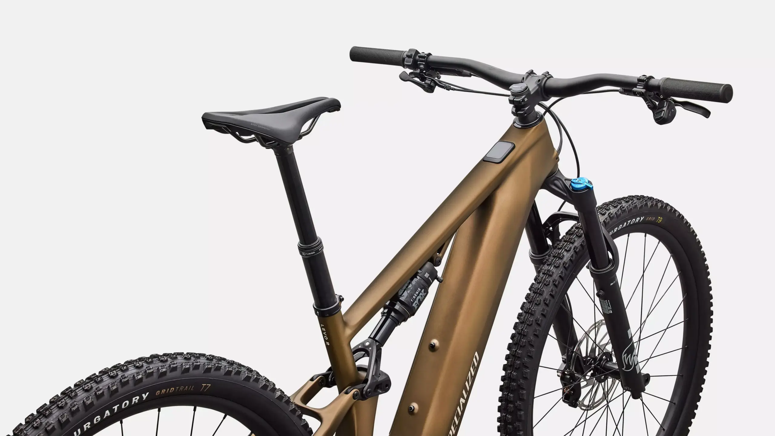Detailansicht des braunen Rahmens eines Specialized Turbo Levo R Comp E-Mountainbikes mit Fokus auf die Federung und Teile des Lenkers und Sattels.