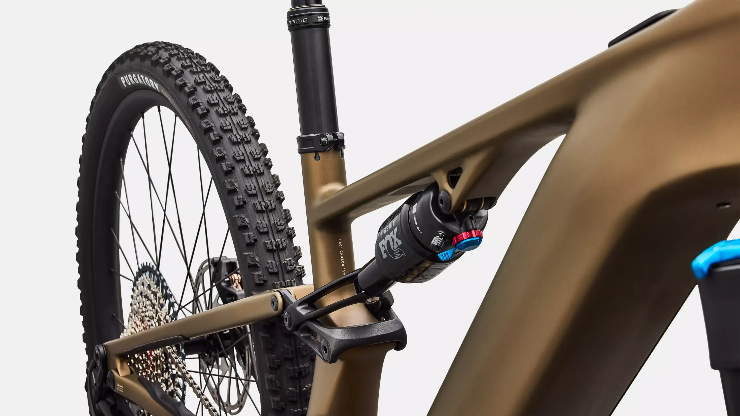 Detailaufnahme eines E-Mountainbikes mit Fokus auf den Dämpfer, die Kette und das Hinterrad