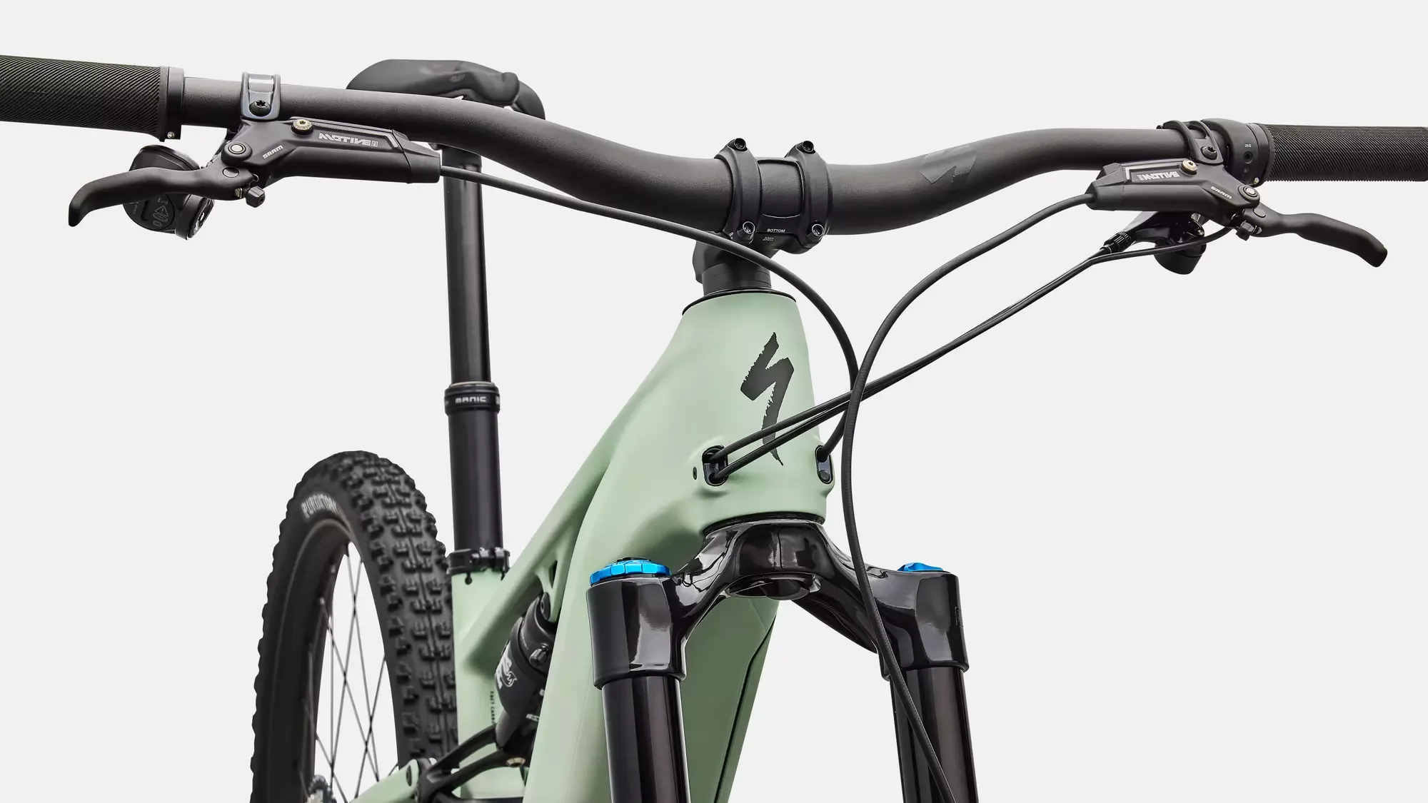 Nahaufnahme des vorderen Teils eines Specialized Turbo Levo R Expert E-Mountainbikes mit hellgrünem Rahmen, schwarzem Lenker, Federgabel und Vorderrad.