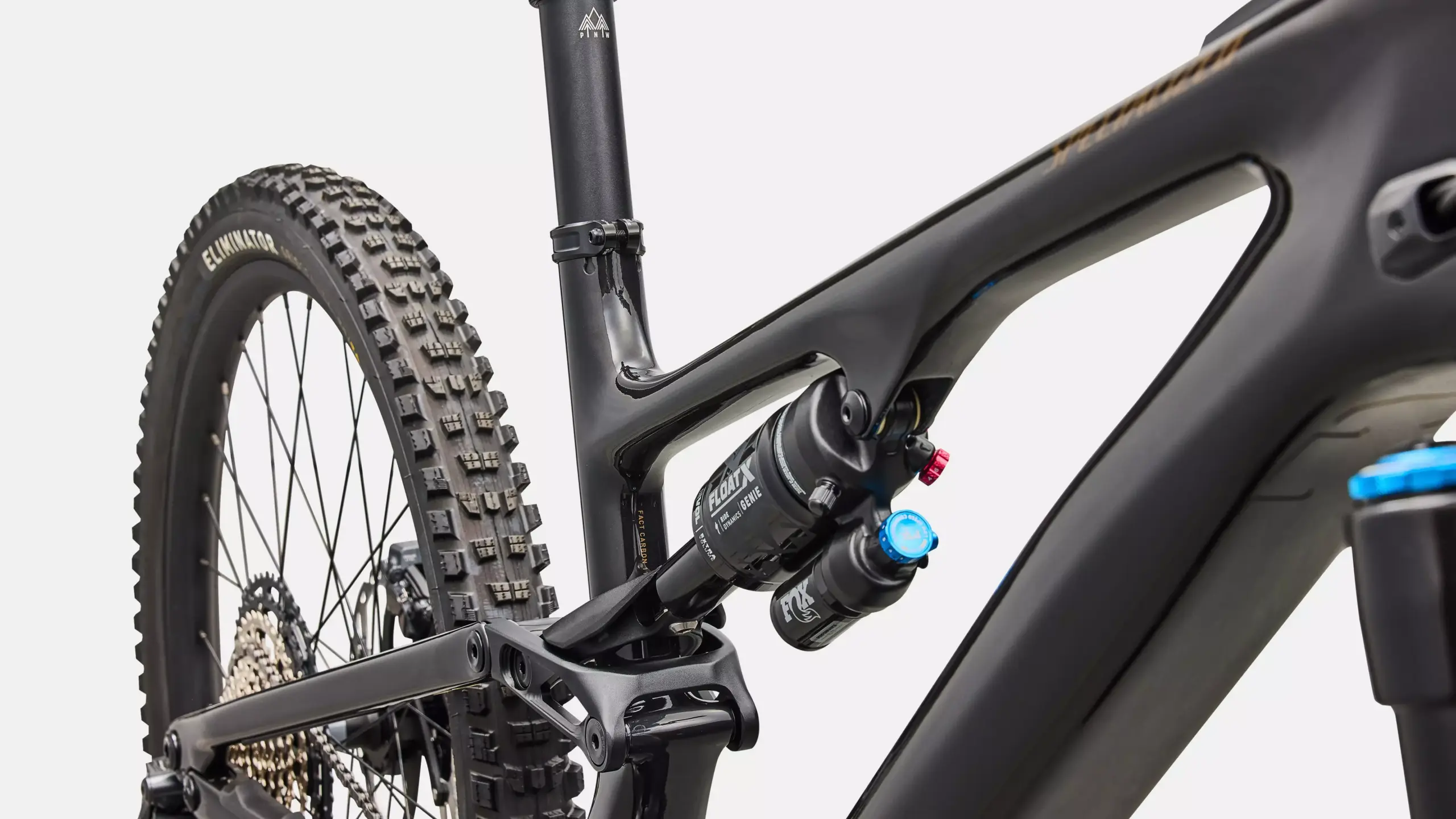 Nahaufnahme des Hinterbaus eines schwarzen Specialized Turbo Levo SL 2 Expert Di2 E-Mountainbikes, wobei der Dämpfer, ein Teil des Rahmens und der ELIMINATOR Reifen sichtbar sind.