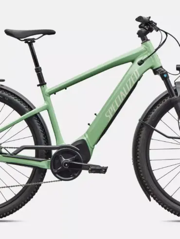 Ein pistaziengrünes Specialized Turbo Tero 4.0 EQ E-Bike mit Gepäckträger, Schutzblechen und integriertem Akku, freigestellt vor weißem Hintergrund.