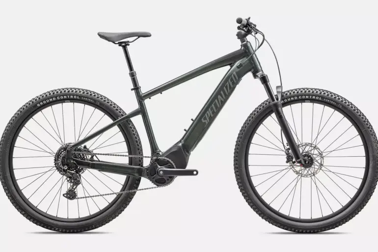 Dunkelgrünes Specialized Turbo Tero 4.0 E-Bike mit 29-Zoll-Rädern, Federgabel und integriertem Akku, in Seitenansicht auf neutralem Hintergrund.