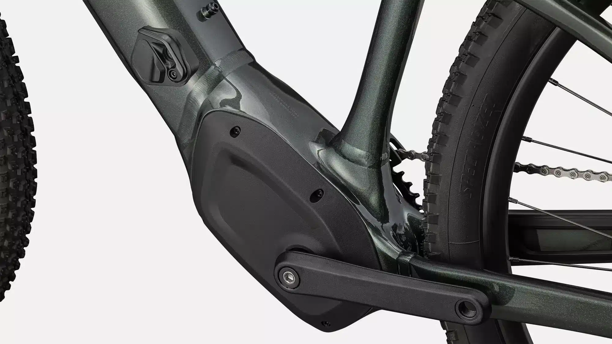Detailansicht des dunkelgrünen Specialized Turbo Tero 4.0 E-Bikes, Fokus auf den Rahmenbereich mit dem Specialized 2.0 Motor, Kurbelgarnitur und dem grobstolligen Hinterreifen.