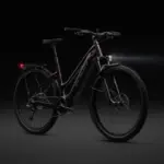 Dunkelrotes Specialized Turbo Tero 5.0 EQ E-Bike mit schwarzem Gepäckträger, Schutzblechen, Vorder- und Rücklicht auf dunklem Hintergrund.