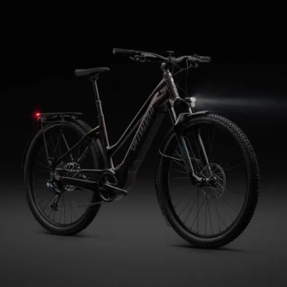 Dunkelrotes Specialized Turbo Tero 5.0 EQ E-Bike mit schwarzem Gepäckträger, Schutzblechen, Vorder- und Rücklicht auf dunklem Hintergrund.